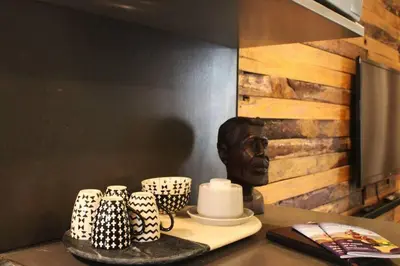 a table with cups and a bust of a man at Well Appointed Apartment by ARPA Hospitalities in Stellenbosch
