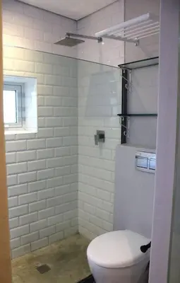 a white bathroom with a toilet and a window at Well Appointed Apartment by ARPA Hospitalities in Stellenbosch