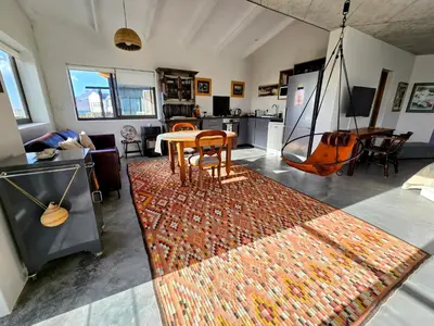 a living room with a table and a rug at Suikerbos in Pringle in Pringle Bay