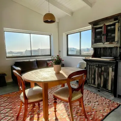 a living room with a table and chairs and a couch at Suikerbos in Pringle in Pringle Bay