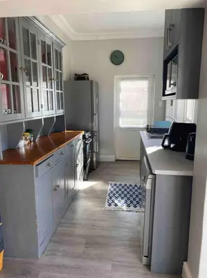 a kitchen with white cabinets and a refrigerator at Auret Street Garden Cottage in Paarl