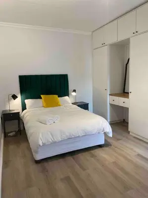 a bedroom with a large bed with two white towels on it at Auret Street Garden Cottage in Paarl