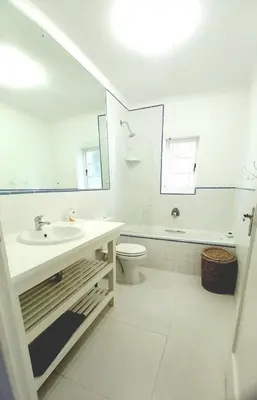 a white bathroom with a sink and a toilet at Grotto Cottage in Hermanus