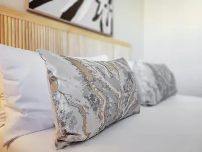 a row of pillows sitting on top of a bed at Walkable, pools, park and great for families in Cape Town