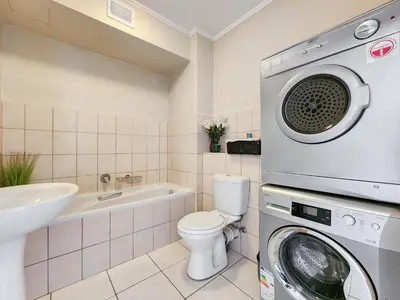 a bathroom with a washer and a washing machine at Walkable, pools, park and great for families in Cape Town