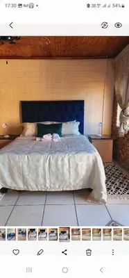 a bedroom with a large bed with a blue headboard at Mercy's Getaway Place in Cape Town
