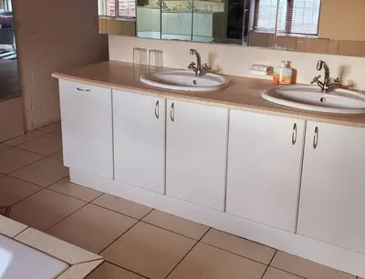 a white bathroom with two sinks and a mirror at Mercy's Getaway Place in Cape Town
