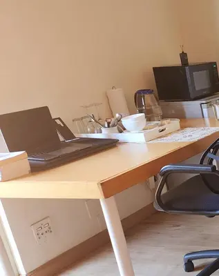 a desk with a laptop computer on top of it at Mercy's Getaway Place in Cape Town