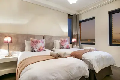 two beds sitting next to each other in a bedroom at Manhattan 1003 in Cape Town