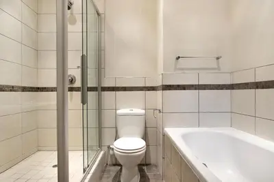 a bathroom with a toilet and a bath tub at Manhattan 1003 in Cape Town