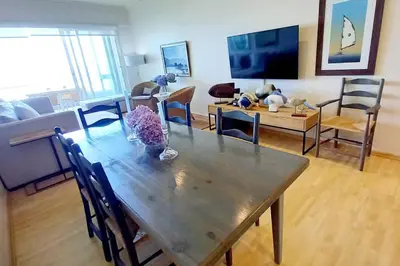 a living room with a wooden table and a couch at 305B Bayview Breathe in Hermanus