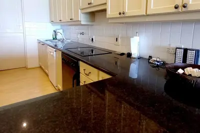a kitchen with a black counter top and white cabinets at 305B Bayview Breathe in Hermanus