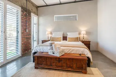 a bedroom with a bed and a table with a box on it at Sunset-Loft in Cape Town