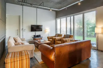 a living room with leather furniture and a flat screen tv at Sunset-Loft in Cape Town