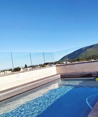 a swimming pool with blue water in front of a building at Apartment at Hermanus Waterfront in Hermanus