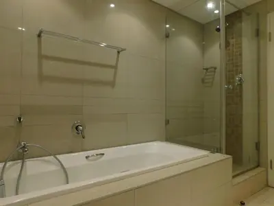 a bathroom with a tub and a glass shower at 97 On Strand in Strand