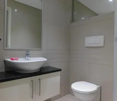 a bathroom with a sink and a toilet at 97 On Strand in Strand