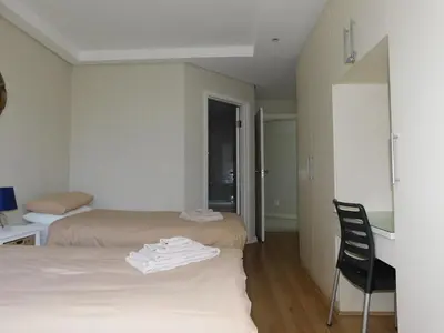 a room with two beds and a desk and a chair at 97 On Strand in Strand