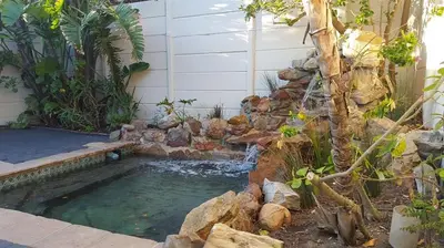 a small pool of water next to a house at Mafari Beach House in Hermanus
