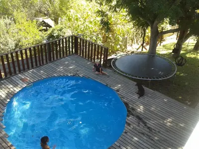 a large blue pool with people sitting around it at Little Lotta Cottage in Caledon