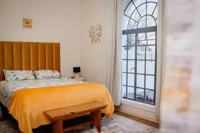 a bedroom with a bed and a large window at Mooi Uitsig Lodge in Paarl