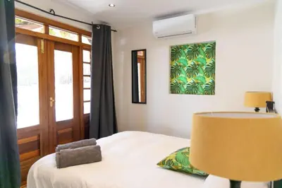 a bedroom with a bed with a lamp and a window at Mitre's Edge Orchard Suite in Klapmuts