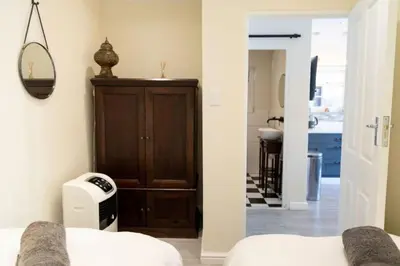 a bedroom with a wooden cabinet in a room at Mitre's Edge Orchard Suite in Klapmuts