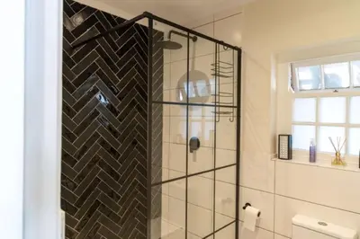 a shower with a glass door in a bathroom at Mitre's Edge Orchard Suite in Klapmuts