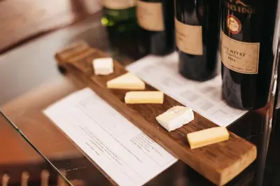 a wooden cutting board with cheese and bottles of wine at Mitre's Edge Orchard Suite in Klapmuts