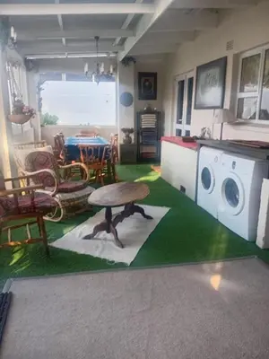 a living room with a table and a washing machine at Out of Africa in Sandbaai, Hermanus in Hermanus