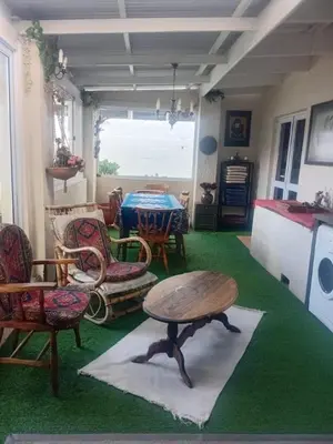 a living room with a table and chairs and a table at Out of Africa in Sandbaai, Hermanus in Hermanus