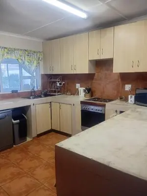 a kitchen with white cabinets and a counter top at Out of Africa in Sandbaai, Hermanus in Hermanus