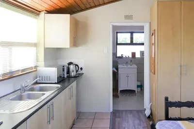 a small kitchen with a sink and a window at Shalom Self Catering in Kleinmond