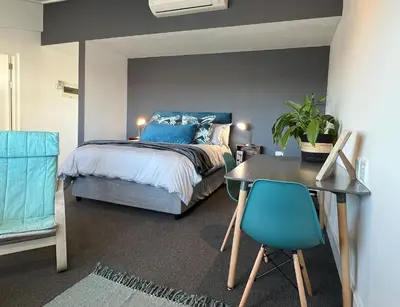 a bedroom with a bed and a desk and a table at Waterfront Studio apartment no 5 in Hermanus