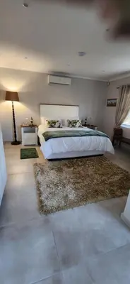 a bedroom with a large bed and a rug at Audrey's Self-Catering Accommodation in Cape Town