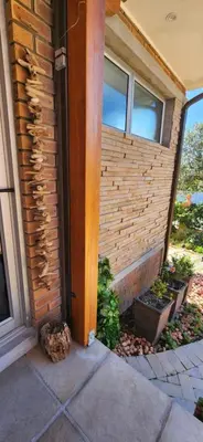a house with a brick wall and a window at Audrey's Self-Catering Accommodation in Cape Town