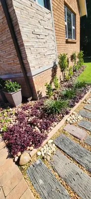a garden with rocks and plants in front of a house at Audrey's Self-Catering Accommodation in Cape Town
