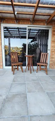 two wooden chairs and a table on a patio at Audrey's Self-Catering Accommodation in Cape Town