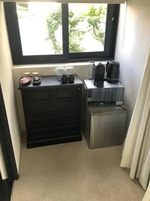 a small kitchen with a microwave and a window at Stellenbosch - Winelands Living Solar in Stellenbosch