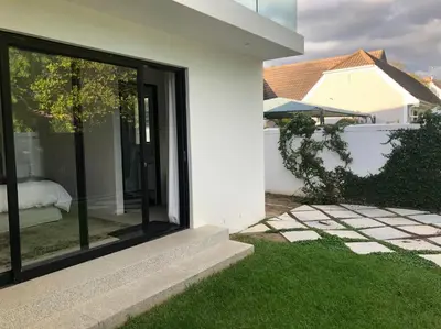 a white house with a sliding glass door at Stellenbosch - Winelands Living Solar in Stellenbosch