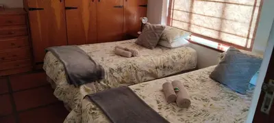 a bedroom with two beds with slippers on them at The 10th Hole - Golf Estate in Villiersdorp