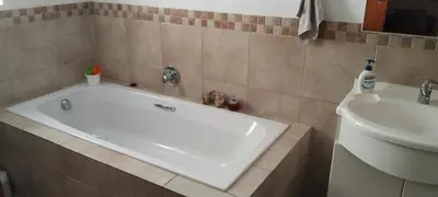 a white tub in a bathroom next to a sink at The 10th Hole - Golf Estate in Villiersdorp