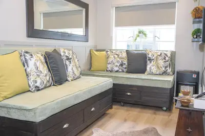 a living room with two benches with pillows at Royal Pearl, Insta-worthy APT in Paarl