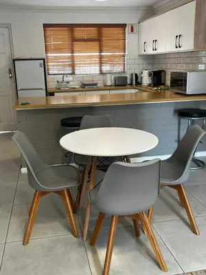 a white table and chairs in a kitchen at Lagoon Lodge in Cape Town