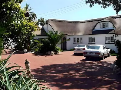 a house with two cars parked in a driveway at Lagoon Lodge in Cape Town