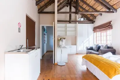 a bedroom with a bed and a sink and a couch at Mead, Pinelands in Cape Town