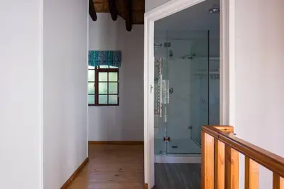a bathroom with a shower with a glass door at Mead, Pinelands in Cape Town