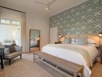 a bedroom with a large bed and a chair at Mount Vernon Manor in Klapmuts