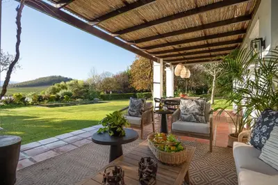 a patio with a wooden pergola and a table at Mount Vernon Manor in Klapmuts