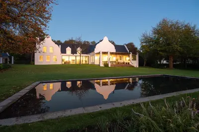 a house with a pond in front of it at Mount Vernon Manor in Klapmuts